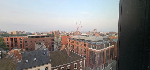 Window view.  Some cranes, a ferry and the Mersey