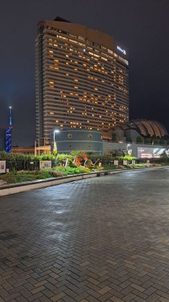 View of the hotel ( and fukuoka tower ) on a damp night from the walkway from the mall around the mizuho paypay dome)