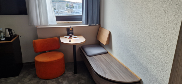 The seating area was perfect to do some laptop work. The window could open (not fully). With the window closed you didn't hear any street noise at all. At the desk a chocolate brownie+berries and a personalized welcome card was greeting me. There's a 0.5 litre bottle of mineral water, I expect it to be in every room, that's rather customary in Germany. The TV had an awful sound quality. There's no fridge in the room, but there is a safe, though it didn't appear to be attached to anything. 