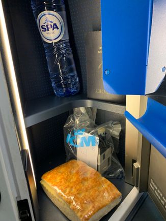 At seat during boarding: water bottle and a ham and cheese sandwich