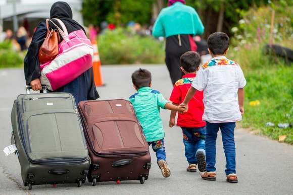 Asylum seekers walk along Roxham Road near Champlain, New York on Aug. 6, 2017, making their way towards the Canada-U.S. border. (Geoff Robins/AFP/Getty Images)