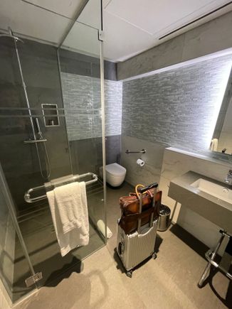 Shower Number 2: At AA arrival lounge at Terminal 3...Super small, felt like a Japanese hotel room, and had to maneuver abit to get clothes out. Good part, there was a luggage rack that had to placed in different spots based if I was using the sink or shower. Modern design!
