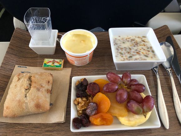 Hearty Granola with nuts, seeds, dried fruit.  Glass of shelf stable milk (I had poured milk on Granola).  Passion Fruit yogurt, grapes, dried apple, pear, apricots, cherries, raisins, figs, and walnuts.  Apple, nut, cinnamon roll with butter.   No PDB but water at seat.  Hot towels.  Excellent and attentive service from friendly FA. 
