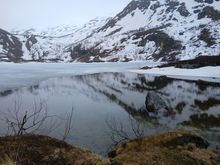 A semi-frozen lake, with reflections in the water