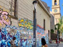 I like the street musician set against the colorful mural.