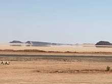 A mirage in the desert - a small line of water appears in the near distance 