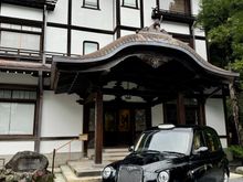 A London taxi parked in front of the wing to the hotel.