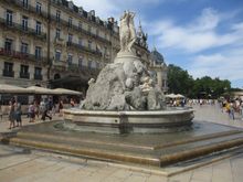By the fountain at Pl de la Comedie, on a bustling Saturday