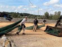 The nets have been emptied into black barrels and then they are dragged back to the truck