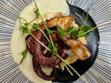 Roasted octopus with parmesan polenta, squid ink cream, white wine emulsion