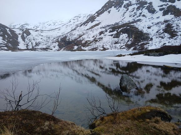 A semi-frozen lake, with reflections in the water