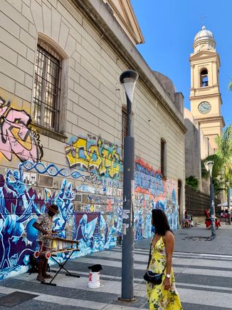 I like the street musician set against the colorful mural.