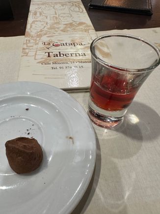 A single chocolate truffle left on the plate!  With a chupito (little shot)  of Baynes pacharán