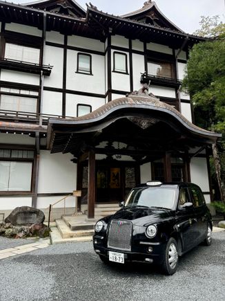 A London taxi parked in front of the wing to the hotel.