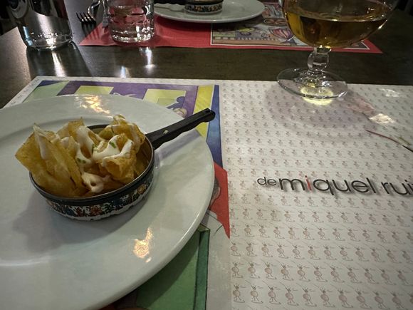 Welcome dish of house-fried potatoes with sauce of berberechos, presented in a little metal pan