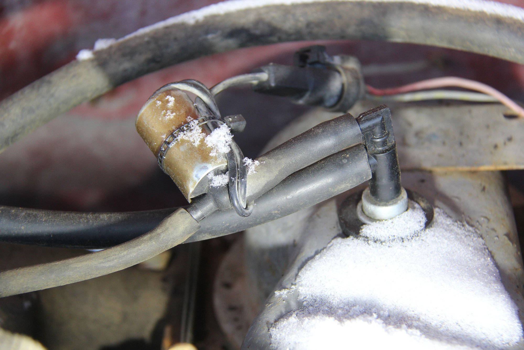 this  is  the  cad plated canister  thing  taped  to the 2  vacuum  hoses  on the  PCV valve..  The  white  stuff  is  snow !!
