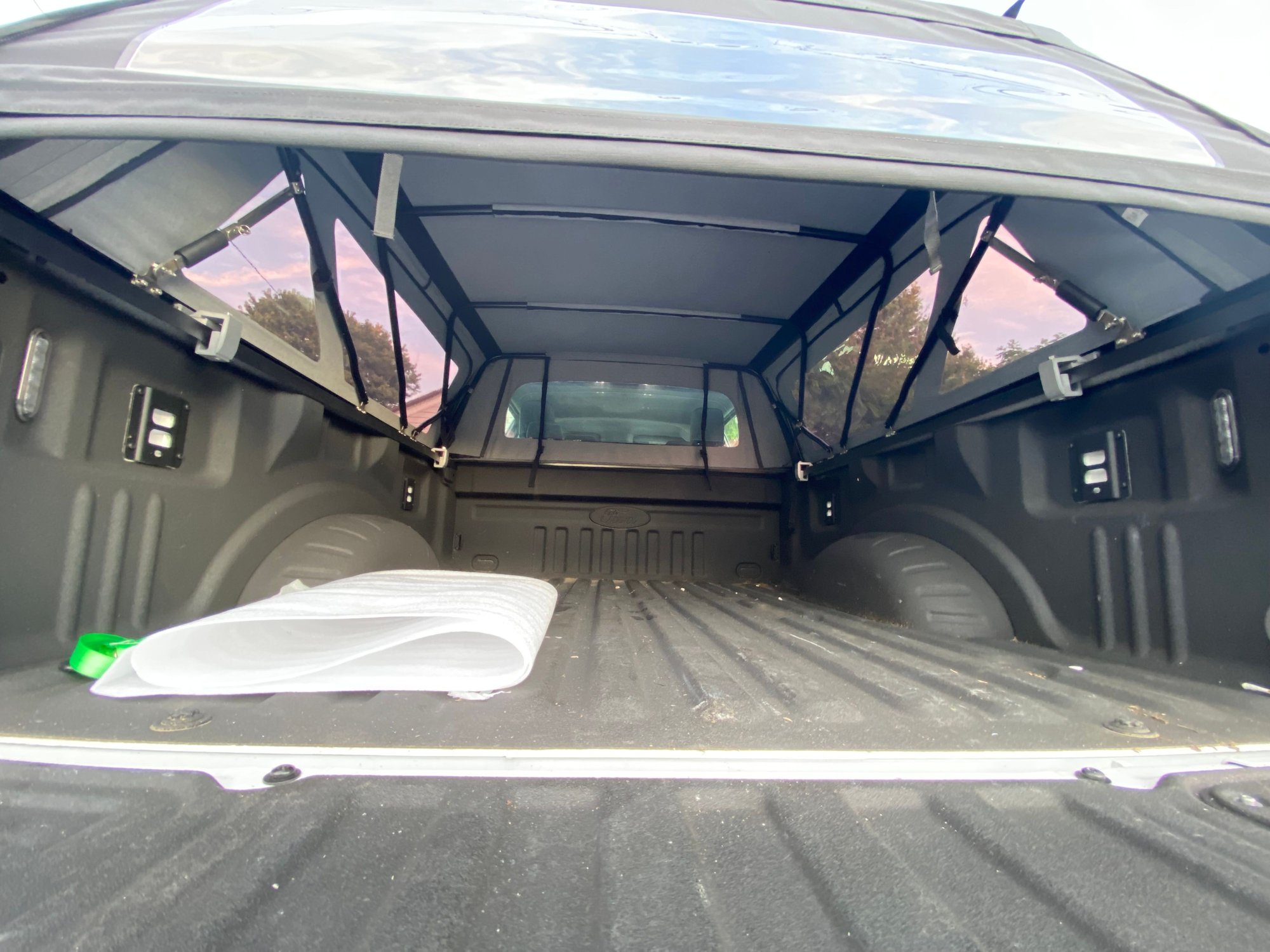Straps at the head of the bed are for securing the retracted frame in the �open� position. Don�t drive above 65 mph as the straps don�t readily offer a way to ratchet or maintain tension. 