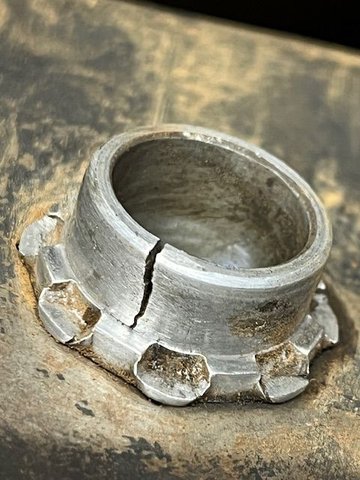 close up of one cracked bushing.  I had a machinist make new bushings from steel by copying the originals and tack-weld them in place from the outboard side.  The originals are a zinc-diecast material pressed and swaged in place as shown.