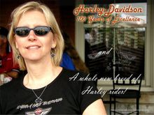 My lovely second wife 'Kea', unwittingly poses for a pseudo-poster I made for the H-D 100th. Note the 'reflections' of nearby office buildings in the glass (and glasses) which were lit up with H-D congratulatory signage during the festival. This was to be the last event we would attend together, before she went her own way, after a short, 5-year marriage! :-( (I still have the bike though! :-))