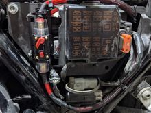 Here is a breaker style fuse with 4 gauge wire. It is tucked under the clutch side, side cover. The 4 gauge is then run up into the fairing where I installed the distribution blocks for the amps. 