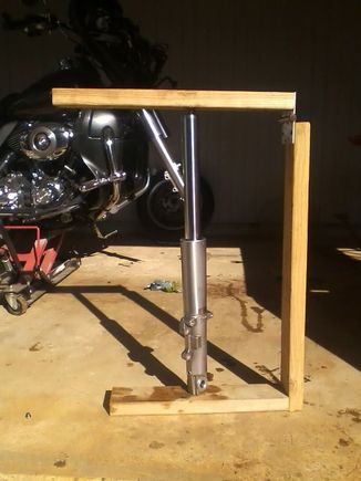 The horizontal top board pushes the cap down and into the fork tube so you can screw the cap in.  Don't us too much force, get it started, don't Xthread it. 