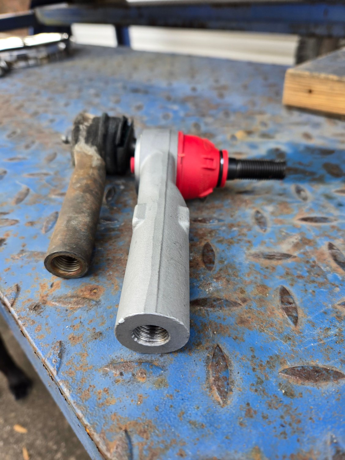 RD tie rod laying next to what I think is the OEM tie rod