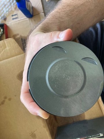 New piston; ensure the valve grooves are on the Exhaust Side of the engine.  I re-emphasize, the small oil control hole on the connecting rods should be facing the exhaust side of the engine as well.  