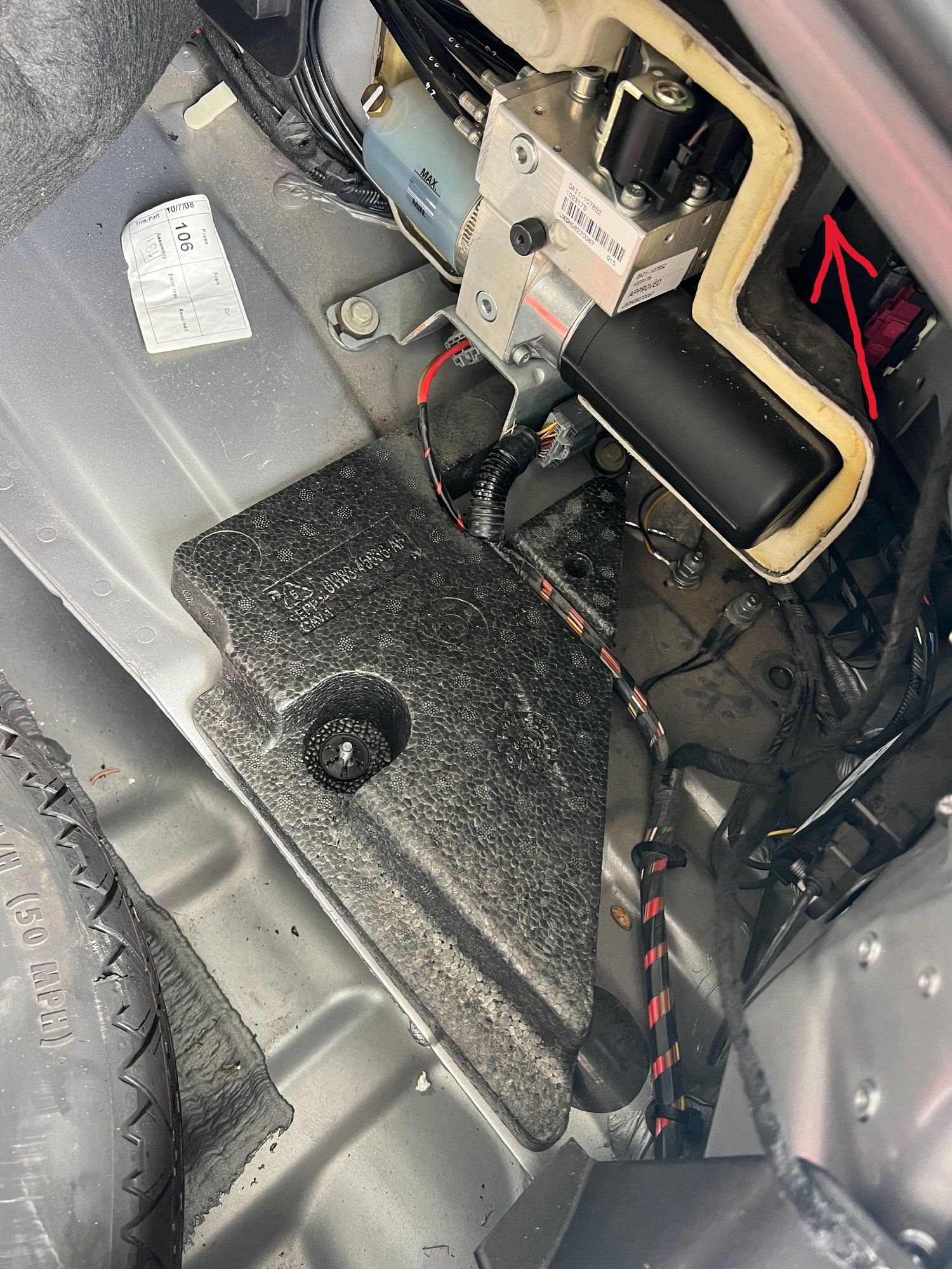 USB/Portable audio module is behind convertible top pump at arrow