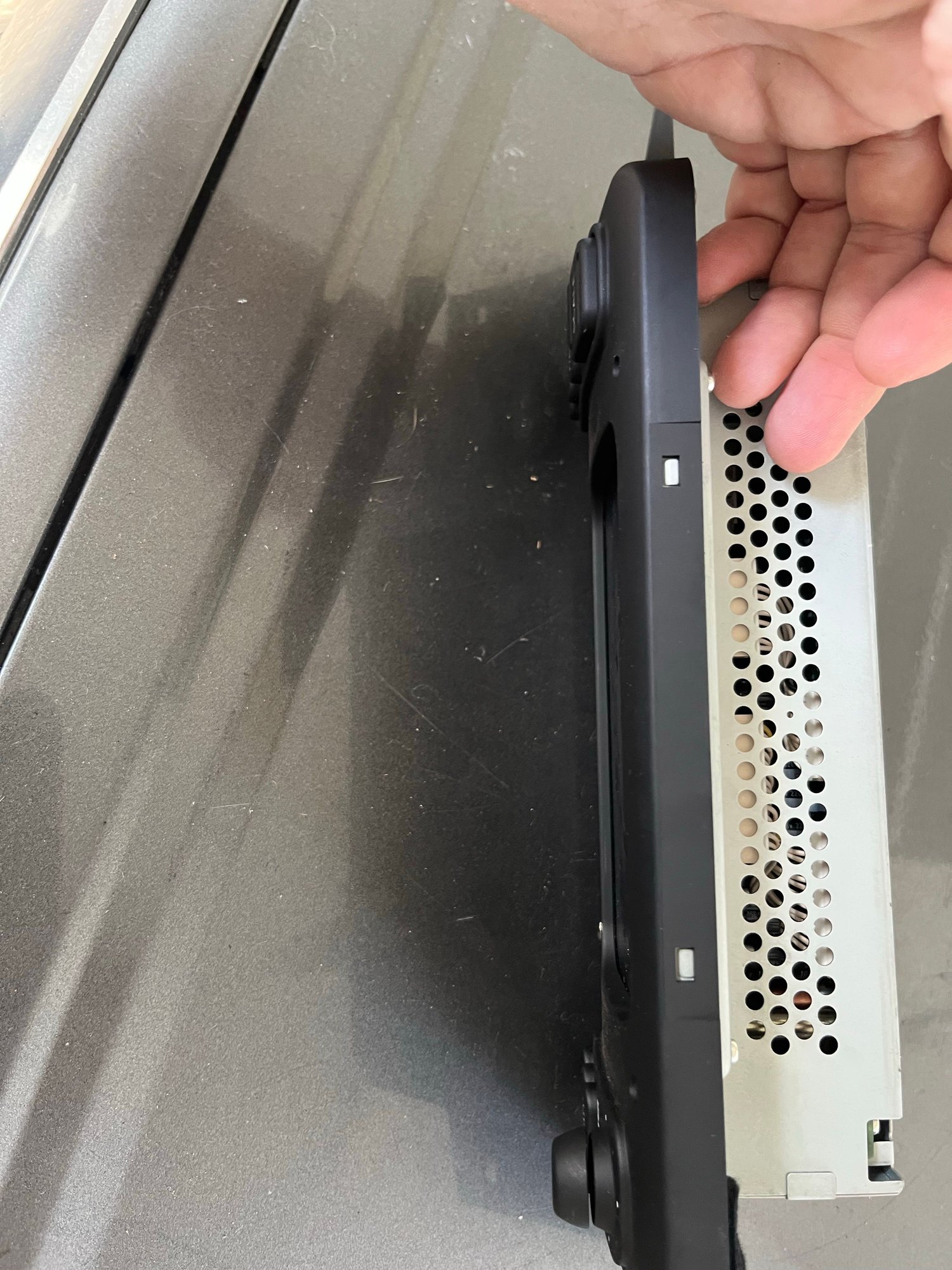 Lift up to clear the metal tabs that catch on the black plastic on the top