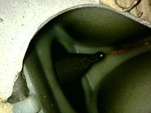 Side camera pointing upward into the hole showing the duck bill protruding horizontally forwards through the firewall