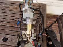 This is the steering column with the bottom cover removed. Linkages and cables now more visible.