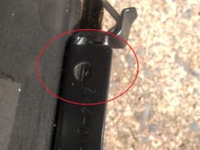 This is the screw whole on the rear of the large interior panel bracket where it mounts to the rear most of the 3 lid screws on each side. View Reference: propped on ground post-removal