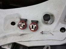 Converting the factory H11 bulb housings to accept the HID bulbs.  The left one is a standard bulb, the right one has the bulb removed in preparation for internal removal.