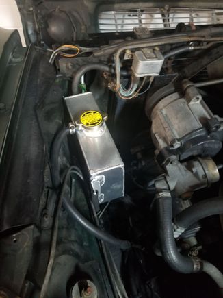 Required removal of windshield washer reservoir. Plan to replace outdated system & relocate.