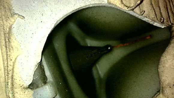 Side camera pointing upward into the hole showing the duck bill protruding horizontally forwards through the firewall