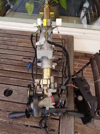 This is the steering column with the bottom cover removed. Linkages and cables now more visible.