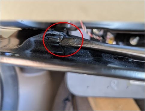 By pulling back on the bracket I was able to push the spring clip to the side to release the fastner.