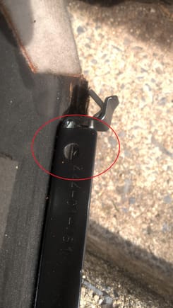 This is the screw whole on the rear of the large interior panel bracket where it mounts to the rear most of the 3 lid screws on each side. View Reference: propped on ground post-removal