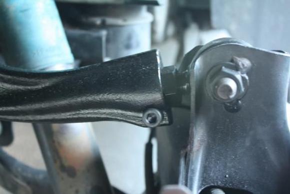 Side view of what the adjuster end looks like once installed in the car.  The allen bolt on the bottom of the arm is what locks the adjuster in place.  Make sure this is tight.  You can also see that the modification has been performed to allow the tire to sit correctly.