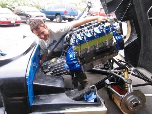Ok, back on track and the excitement is definitely ramping up.  So, here we gowith a little help from an old engine crane and some grunting from little browe started slipping the engine and trans into the chassis.  You can tell how joyous and event this was from the big grin on my bro's face...LOL  Piece of cakenot
