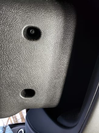 The Lower steering cover viewed from below. One of the two T20 torx fasteners is visible in this photo. Remove both screws and gently disengage bottom cover from the top.