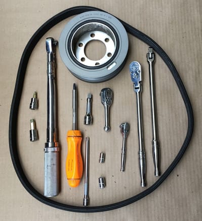 Tools used to replace crankshaft pulley, along with original pulley and belt.