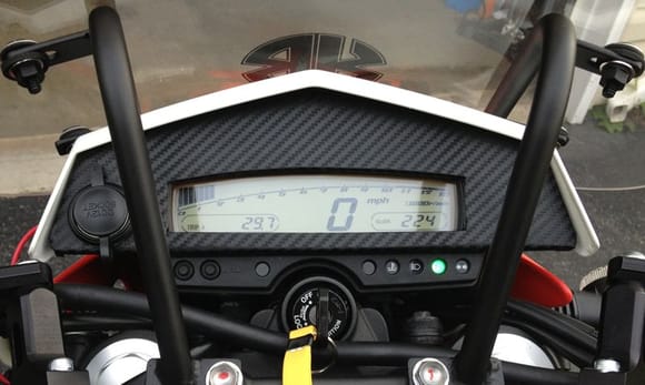 I never liked the open area around the speedometer. I also needed a place to put a power outlet. I made a dash panel out of a plastic kitchen cutting board and wrapped it in carbon fiber vinyl.
