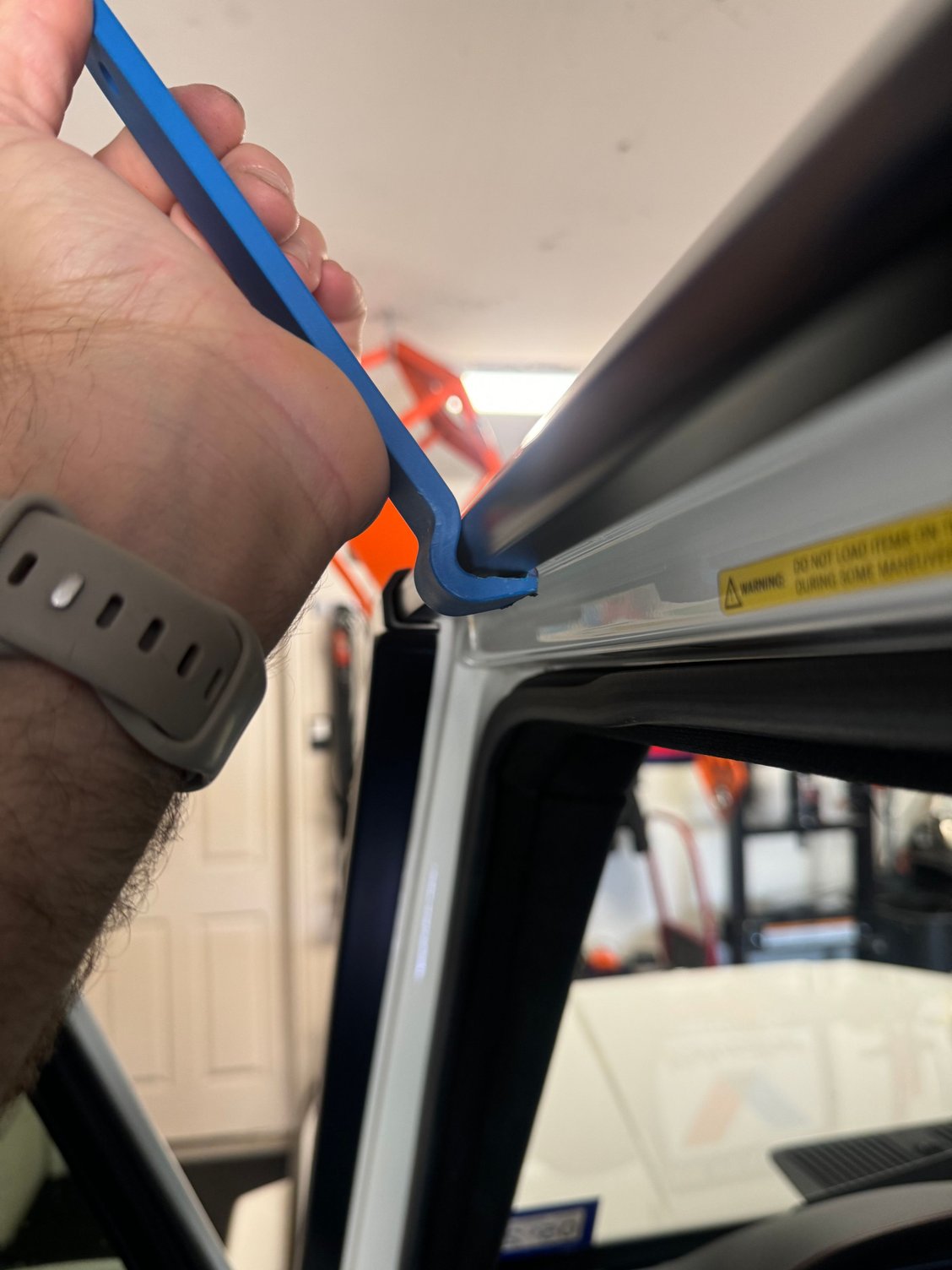 Pull up like a bottle cap. Start on one end and work slowly making two passes. This will ensure the old one comes off easily without scratching anything.
