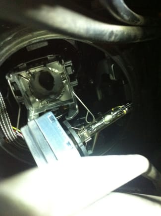 The HID headlight bulb will easily slip out.  At this point, using one hand, disconnect the braided wire connector from the base.  The wire connector will slide off with a simple pull.