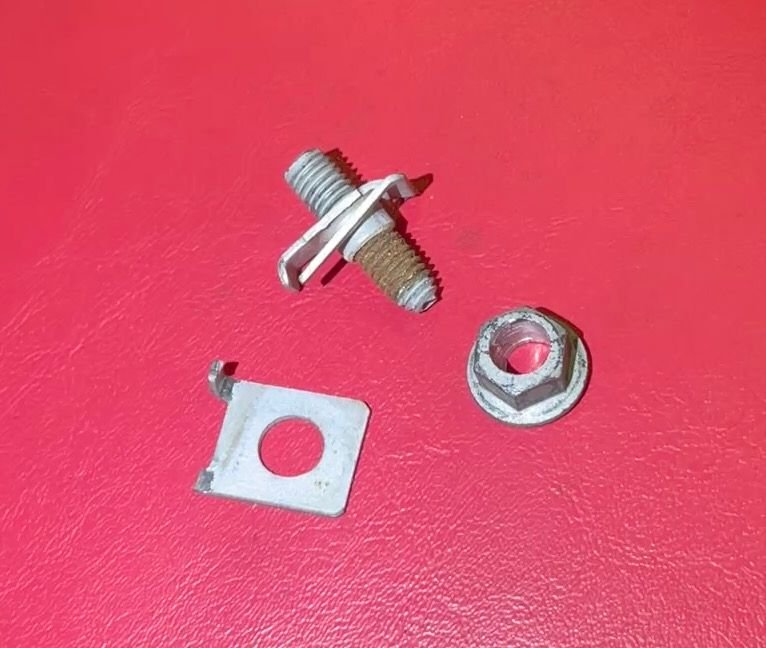 Broken spring nut clip with rusted bolt and head removed.