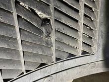 Tire rubber slag damage on the vent louvers for the auxiliary radiator.