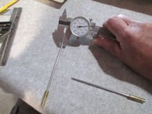 The stainless steel drive shaft is measured using a dial caliper.  