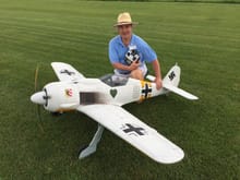 Post maiden photo of my Top RC FW 190. I made Walter Nowotny's plane. Flew great with a DLE 111, Sierra Retracts, and 58 degrees of flaps which is what the full scale used. I installed a IFlyTallies cockpit. After the second flight I discovered hair line cracks in the empenage so I cut open the bottom of the plane last night and put carbon fiber mat all the way around the inside of the empenage. The stock gear doors handled the thick grass at our field as you can see in the photo.