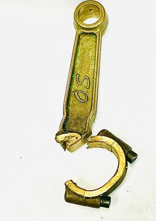 A photo of my broken rod.Note screws are soundly intact.
Note stretched big end and dented sides from striking sides of cylinder opening as the big end opened prior to letting go.   The added mass takes its toll.
   The crankpin journal showed no signs of bearing stress.A used set of aluminum rods were fitted and AFAIK the engine is still fine.  

      All of the aluminum rod failures I know of showed definite signs of bearing failure. Metal transfer, scoring and heat discoloring. Who knows?